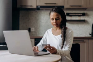 woman at laptop holding a credit card