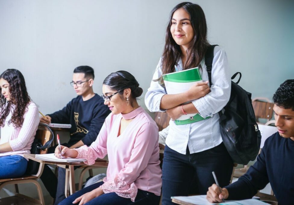 woman carrying white and green textbook photo